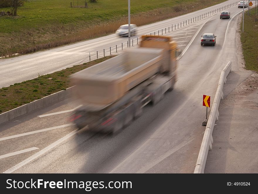 A truck travelling at high speed at the highway. A truck travelling at high speed at the highway