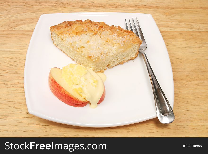 Apple cake and fresh cream on a white plate with fork