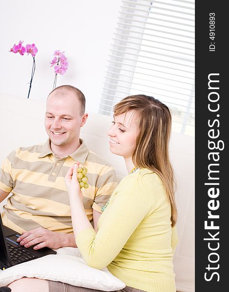 Smiling couple with laptop on a couch. Relax at home. Smiling couple with laptop on a couch. Relax at home.