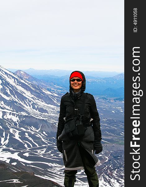 The young woman on background volcano. Kamchatka. The young woman on background volcano. Kamchatka