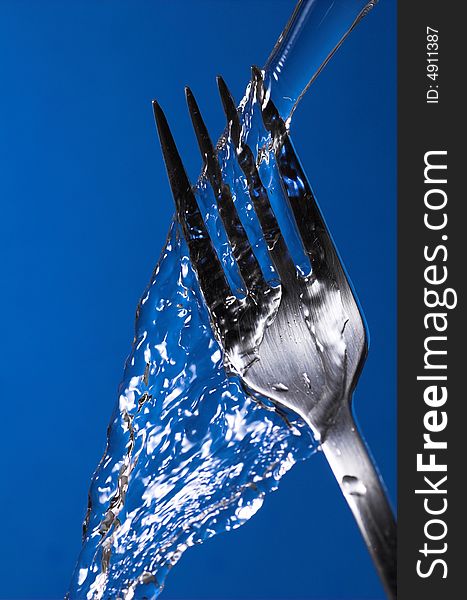Fork under water over blue background - hygiene concept