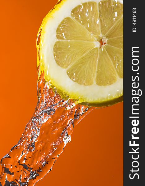 Lemon slice and water over orange background