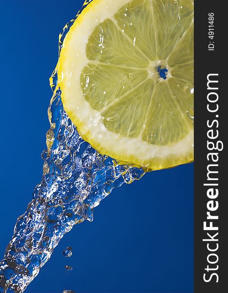 Lemon slice and water over blue background