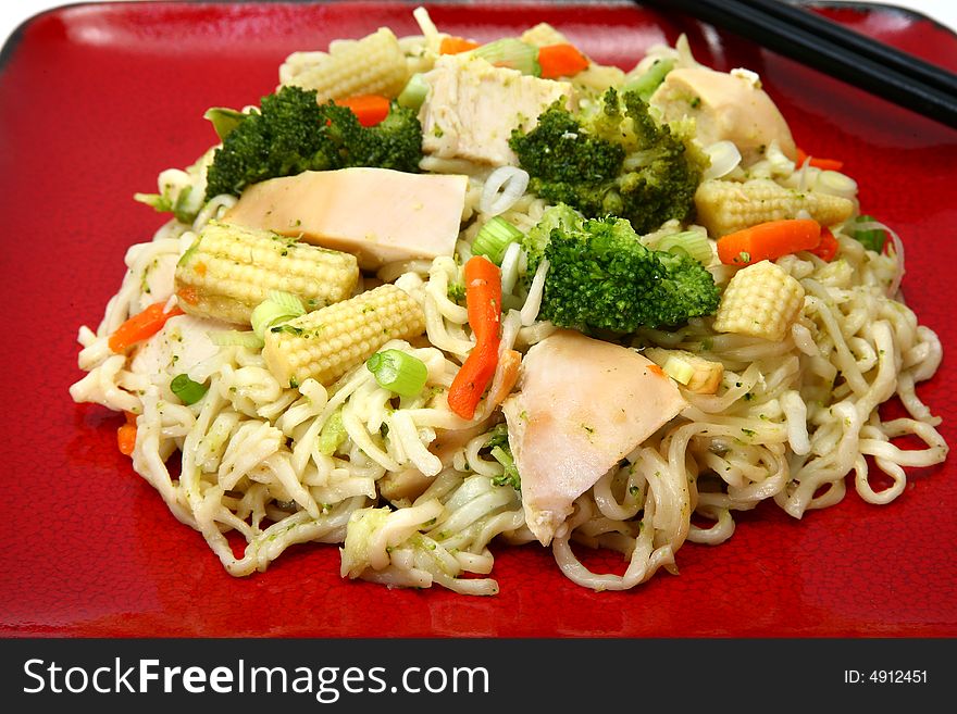 Plate of chicken stirfry with noodles and veggies.