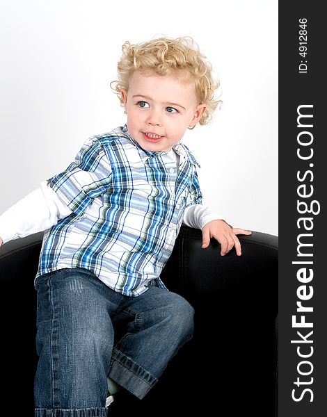 A young boy posing on a chair. A young boy posing on a chair