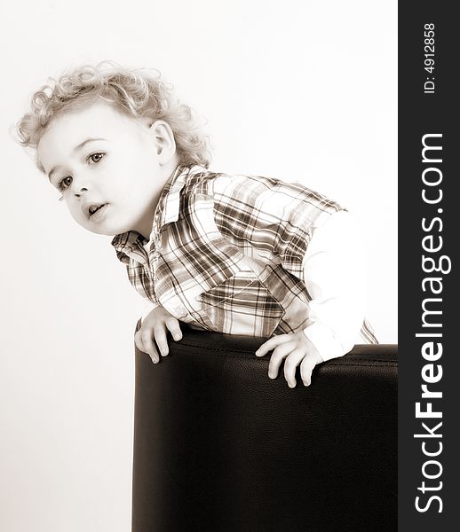 A young boy posing on a chair. A young boy posing on a chair