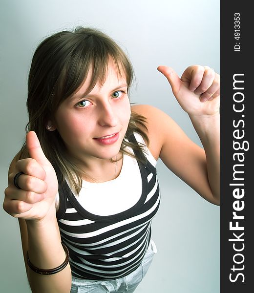 A pretty blond girl viewed from above and she shows her thumbs betoken her approval. A pretty blond girl viewed from above and she shows her thumbs betoken her approval