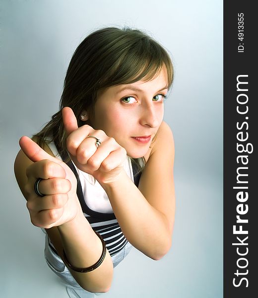 A pretty blond girl viewed from above and she shows her thumbs betoken her approval. A pretty blond girl viewed from above and she shows her thumbs betoken her approval