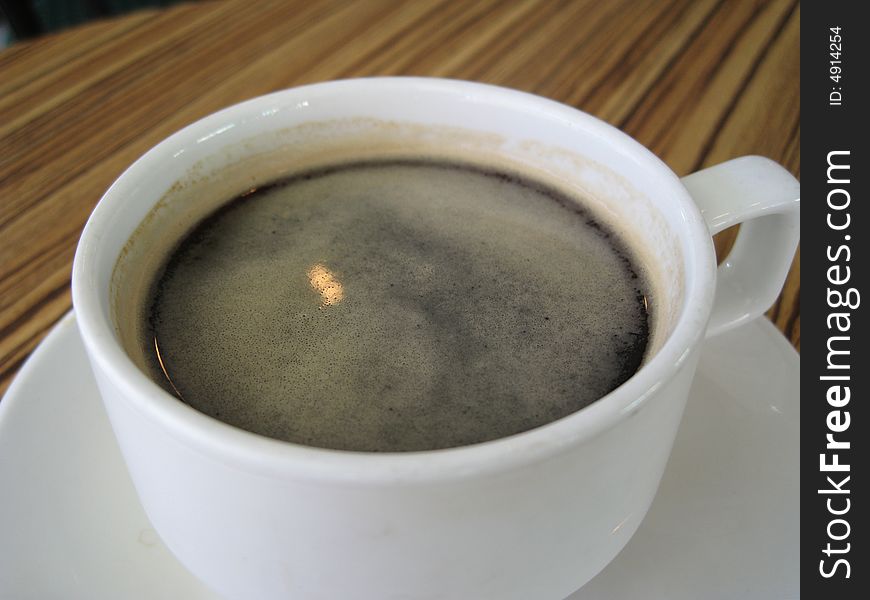 Close up for a cup of black coffee on a table in a cafe