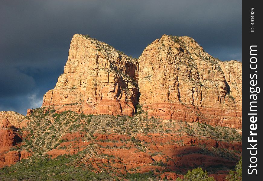 Red rocks of Sedona in the sun with black clouds rolling in. Red rocks of Sedona in the sun with black clouds rolling in.