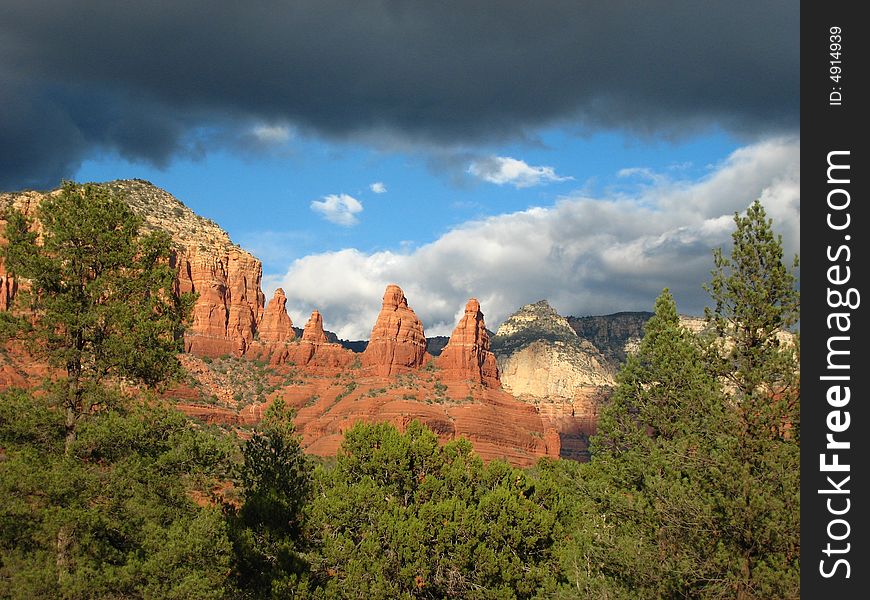 Red rocks of Sedona in the sun with black clouds rolling in. Red rocks of Sedona in the sun with black clouds rolling in.
