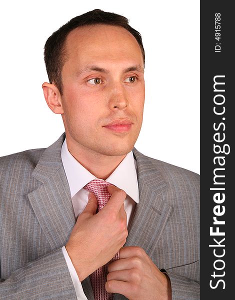 Young businessman corrects necktie on white. Young businessman corrects necktie on white