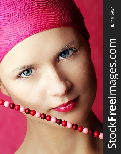 Beauty portrait of a young woman in pink with a chain. Beauty portrait of a young woman in pink with a chain