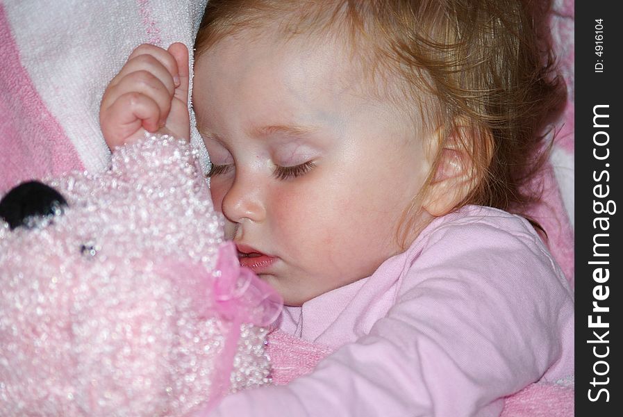 The beautiful girl in a pink T-short sleeps with her toy. The beautiful girl in a pink T-short sleeps with her toy
