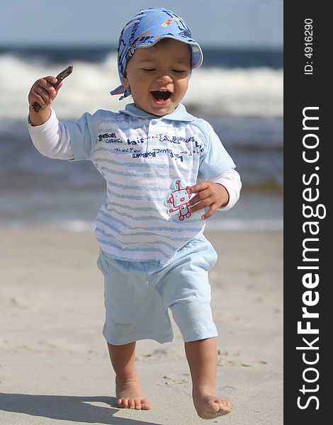 Happy young boy on the beach in the sunny day