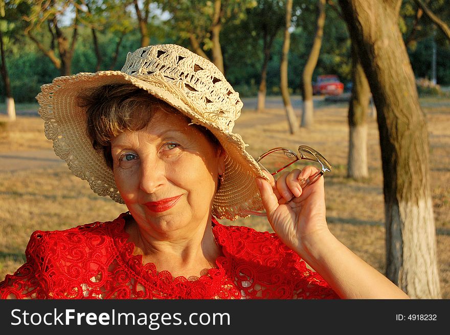 The elderly woman, smile, hat, sunset. The elderly woman, smile, hat, sunset.