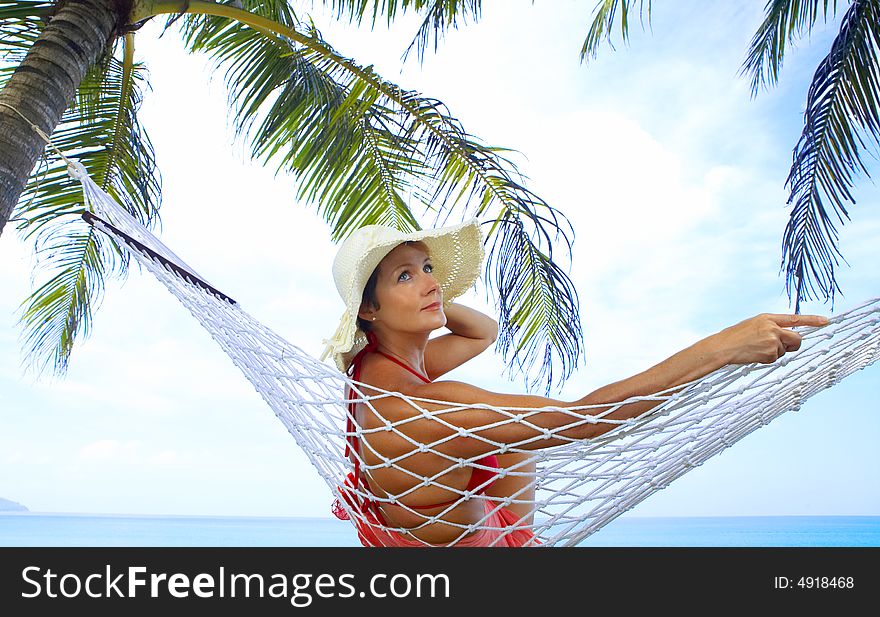 View of nice woman lounging in hammock in tropical environment. View of nice woman lounging in hammock in tropical environment