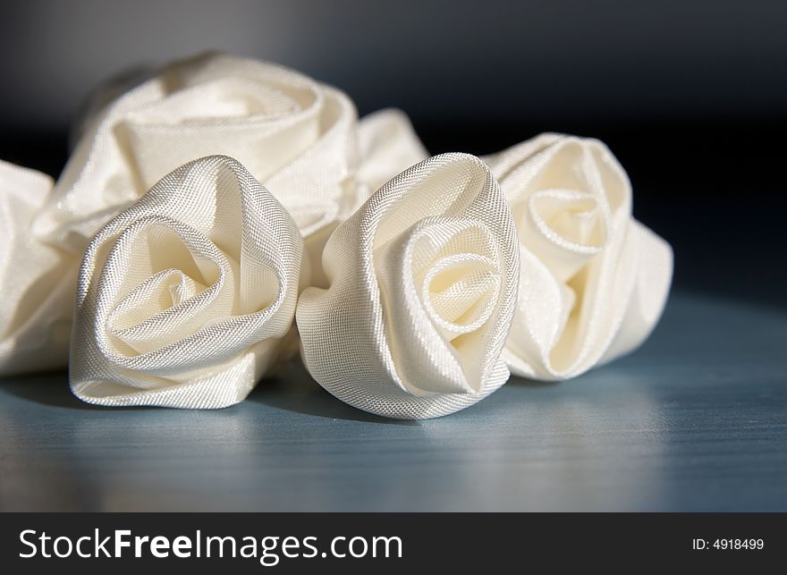 Artificial flowers from the white atlas for an ornament of a hairdress of the bride. Artificial flowers from the white atlas for an ornament of a hairdress of the bride