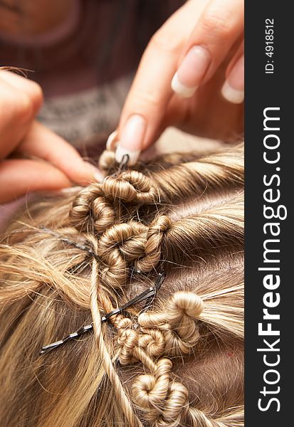 Hands of the hairdresser doing celebratory stacking of hair to the bride. Hands of the hairdresser doing celebratory stacking of hair to the bride