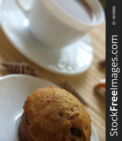 Close up muffin with cup of coffee in background. with little DOF