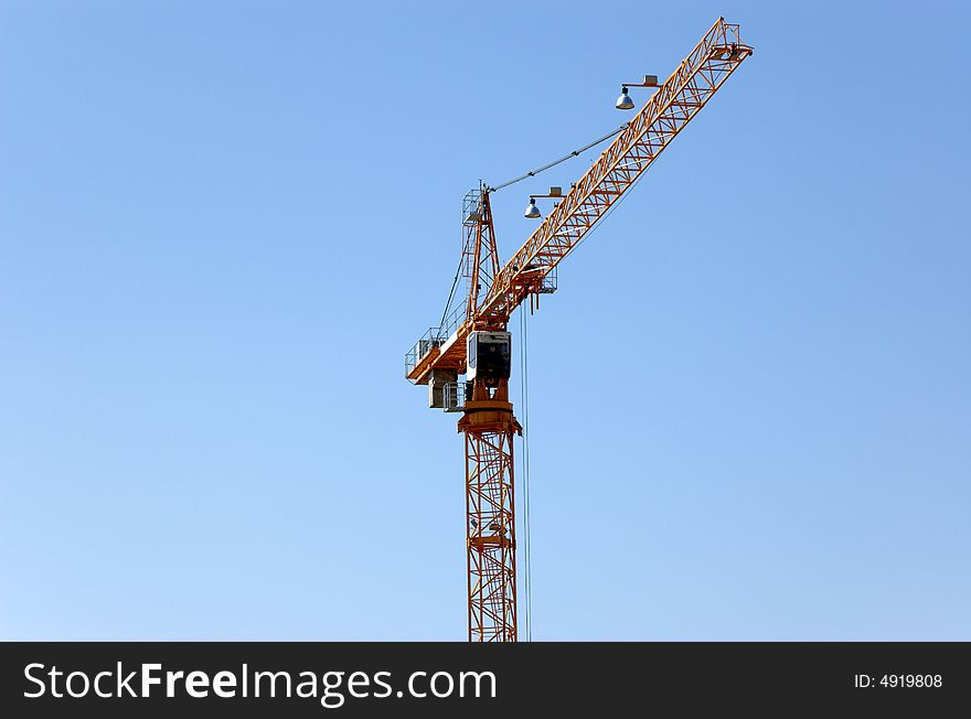 Lifting crane building the house on a blue sky