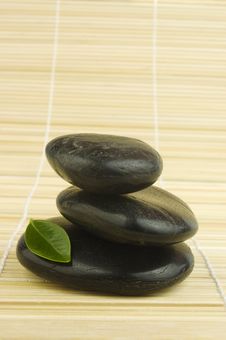 Black Zen Pebbles And Green Leaf On Bamboo Royalty Free Stock Photos Black Zen Pebbles And Green Leaf On Bamboo Royalty Free Stock Photos