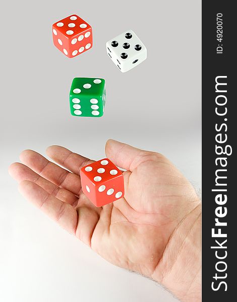 Hand and a set of dice on gray background