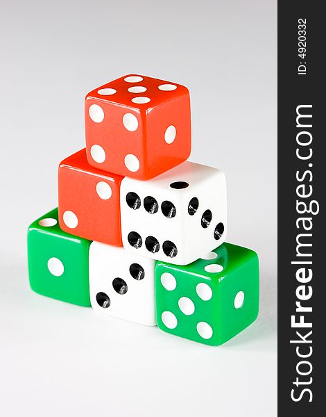 Six dice pieces in various colors, on gray background