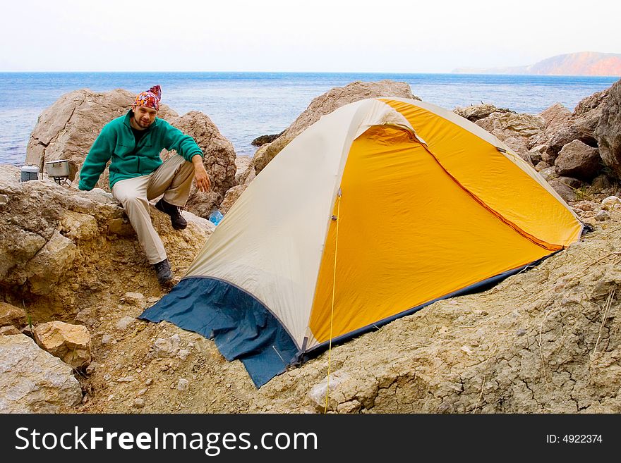 Man near a tent ashore sea. Man near a tent ashore sea