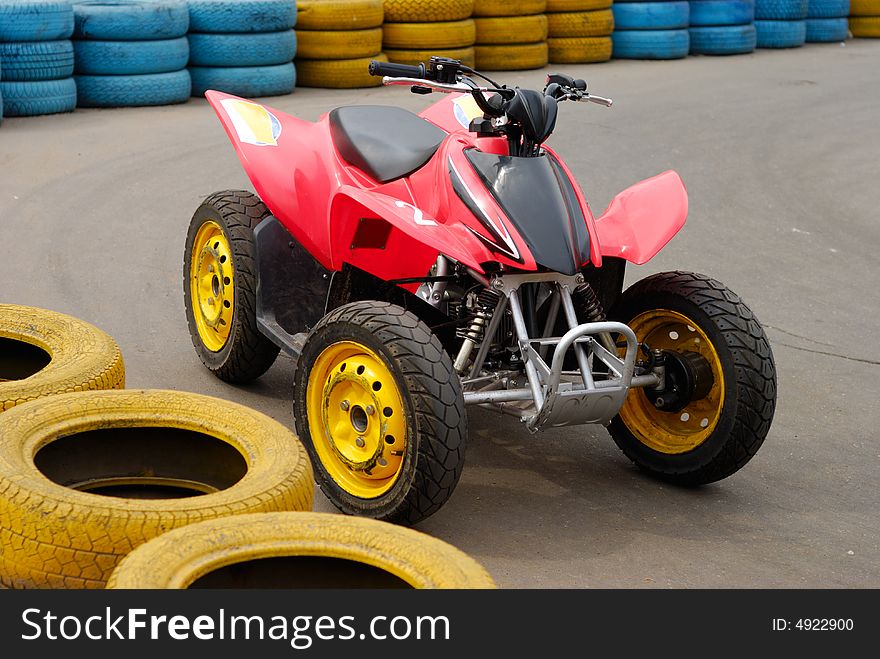 Single 4-wheeler near tyre bounds of race road. Urban scene. Single 4-wheeler near tyre bounds of race road. Urban scene.