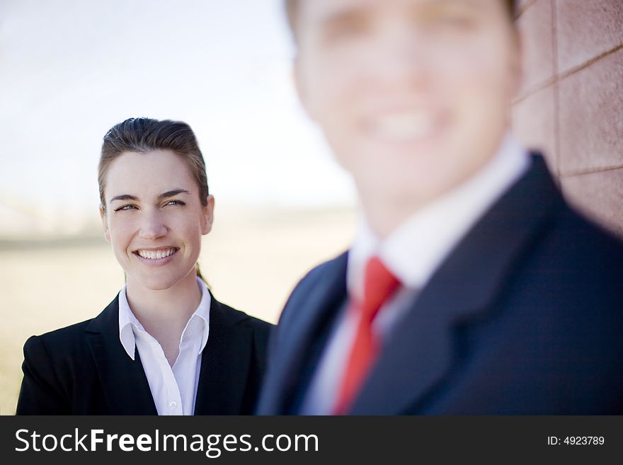 Businessman and businesswoman wearing suits and smiling. Businessman and businesswoman wearing suits and smiling