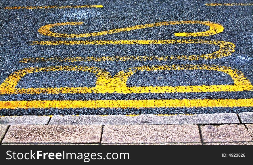 BUS painted onto road tarmac to signal a bus stop. BUS painted onto road tarmac to signal a bus stop