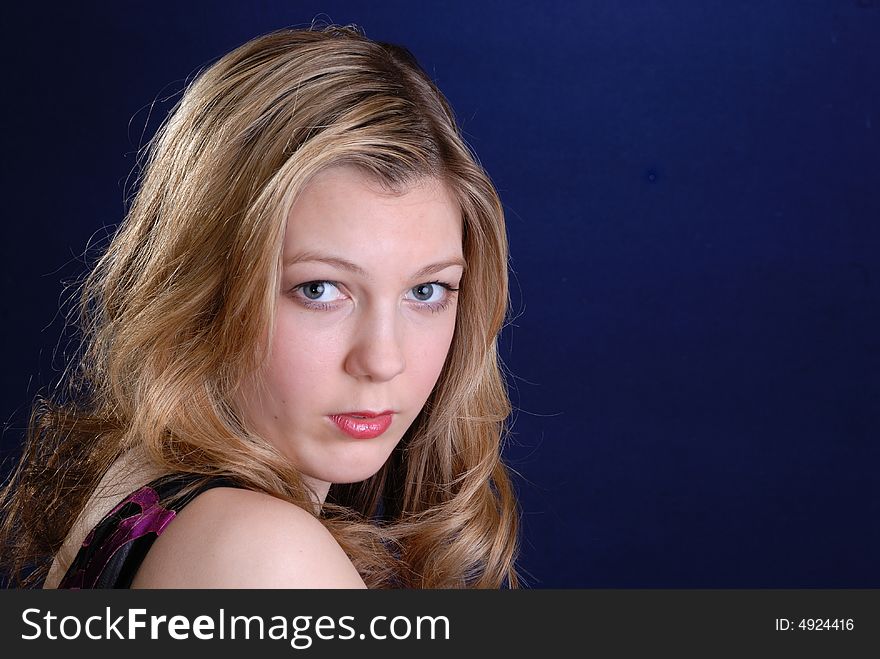 Pretty young blonde  teenage girl on dark blue background. Pretty young blonde  teenage girl on dark blue background