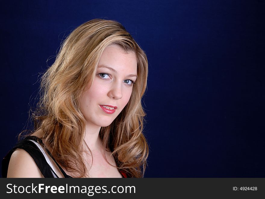 Pretty young blonde  teenage girl on dark blue background. Pretty young blonde  teenage girl on dark blue background