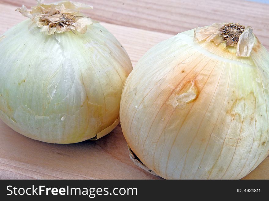 White onions ready to be sliced on the cutting board