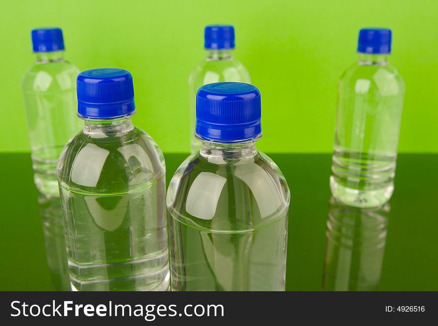 Bottled water isolated against a green background