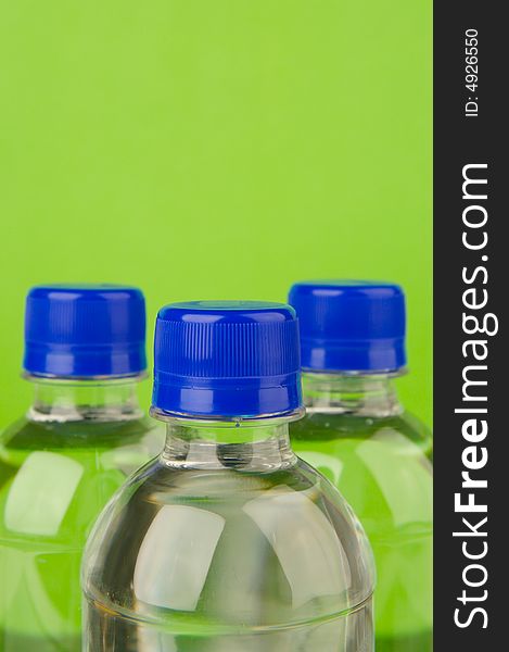 Bottled water isolated against a green background
