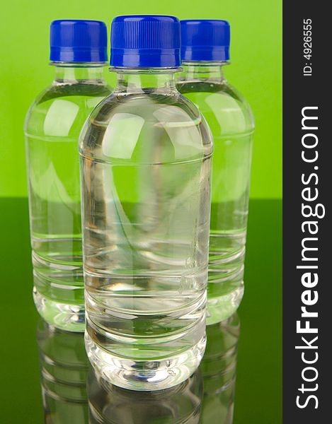 Bottled water isolated against a green background