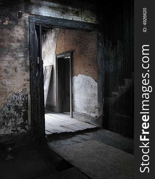 A burned archway in an old abandoned brick building with light spilling in from afar. A burned archway in an old abandoned brick building with light spilling in from afar.