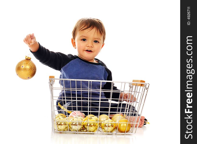 Happy baby boy playing in a wire basket of gold colored Christmas bulbs.  Isolated on white. Happy baby boy playing in a wire basket of gold colored Christmas bulbs.  Isolated on white.