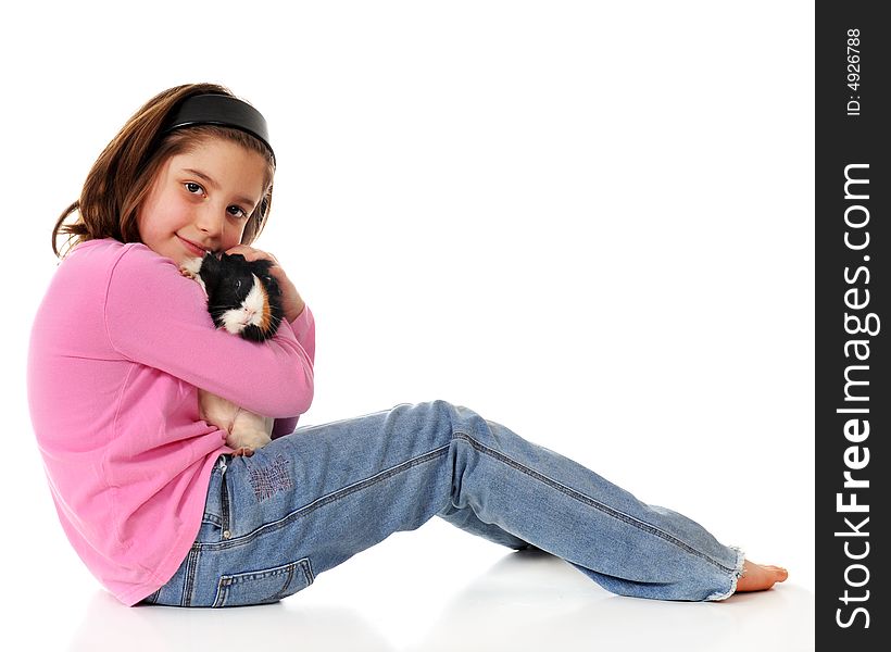 Elementary girl snuggling with her pet guinea pig. Isolated on white. Elementary girl snuggling with her pet guinea pig. Isolated on white.