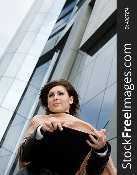 An image of a girl with notebook on background of building. An image of a girl with notebook on background of building