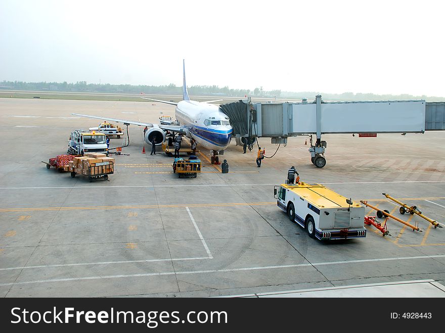 The workers are uploading luggages on an passenger airplane. The workers are uploading luggages on an passenger airplane.