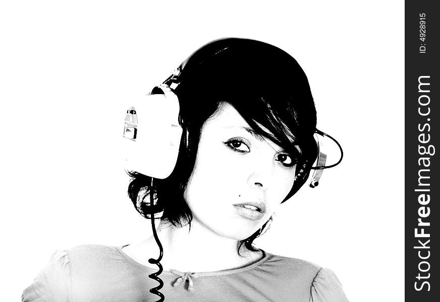 A beautiful young woman gazes with headphones on. A beautiful young woman gazes with headphones on