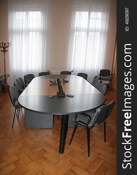 Empty boardroom meeting area with wooden floor