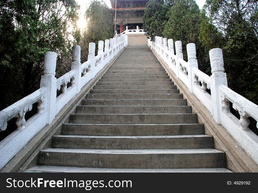 The ascending stone steps up to the mountain top with marble pattered carved railing,ancient Chinese mountain steps . The ascending stone steps up to the mountain top with marble pattered carved railing,ancient Chinese mountain steps .