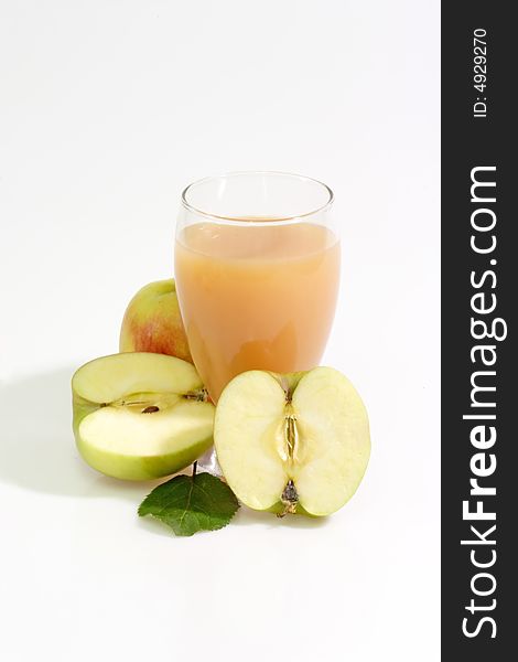 A glass of apple juice with fresh apples on bright background. A glass of apple juice with fresh apples on bright background