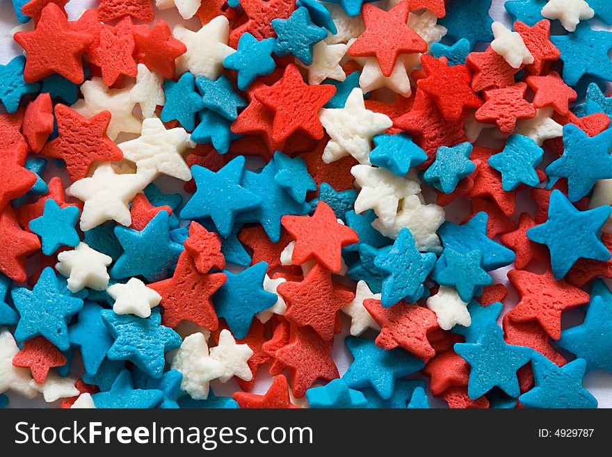 Confectionery ornament in the form of blue, red and white stars close up. Confectionery ornament in the form of blue, red and white stars close up