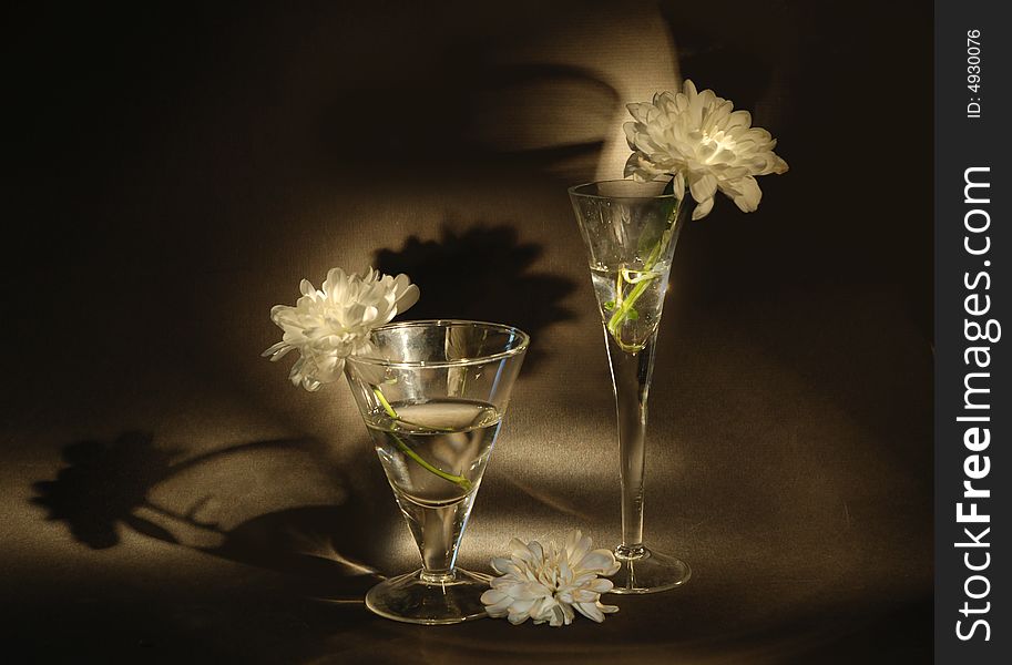 Two glasses and flower on  black background