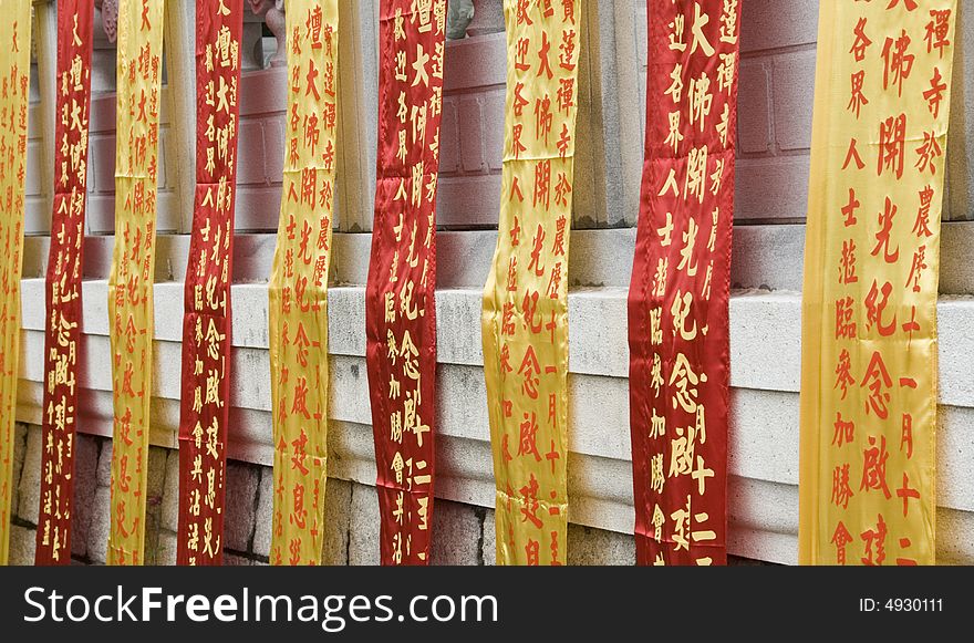 Chinese Buddhist prayer ribbons hanging at a monastery wall on Lantau